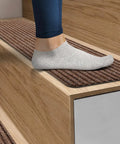 Person walking on wooden stairs with Non Slip Stair Treads For Indoor Stairs 30x8 Inches Pack Of 15 Brown Anti Slip Stair Covers