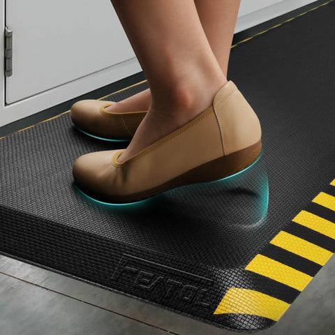 Person standing on Anti Fatigue Standing Mat For Workstation Ultra Cushy High Density Memory Foam Ergonomic Floor Pad To Fight Leg And Back Pain Industrial Grade Durability 24 By 70 Inches With Yellow Border