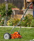 Man using 1204-14 14-Inch 4-Blade Push Reel Lawn Mower with lightweight 19-pound body and 8.5-inch polymer wheels on lawn