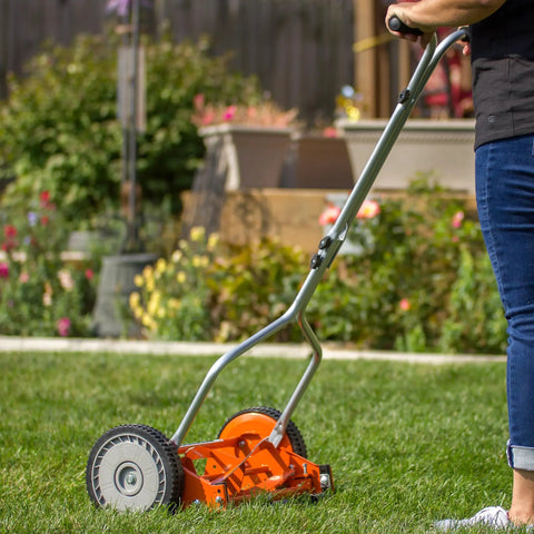 Man using 1204-14 14-Inch 4-Blade Push Reel Lawn Mower with lightweight 19-pound body and 8.5-inch polymer wheels on lawn