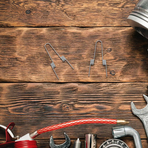 Ditch Your Wonky Flip Lid With These Rock Solid Stainless Steel Torsion Springs And Make DIY Repairs A Breeze For Any Trash Can In The Kitchen Or Home, two silver torsion springs on wood