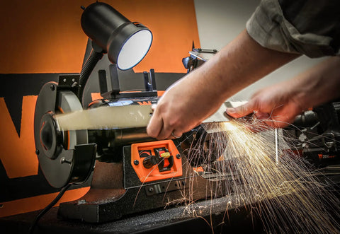 Badass Heavy Duty Workhorse Bench Grinder And Belt Sanders Combo With Variable Speed Motor in use for tool sharpening.