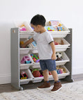 Child organizing toys in 12 bin toy storage organizer for kids playroom, 4-tier in grey and white with durable wood frame and steel dowels.