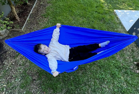 Kid Friendly Camping Hammock For Indoors And Outdoors, Ultra Comfy Hangout Hammock For Kids with child lying in blue hammock