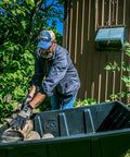 Man loading rocks into Heavy Duty Lawn And Garden Trailer With 900 Lb Capacity 15 Cu Ft Poly Tub Tilt And Pivot Frame Sealed Bearings