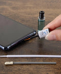 Phone Laptop Tablet All In One Cleaning Kit With Precision Spudgers, tweezers, DeoxIT D100L, swabs, and micro brushes shown with phone.