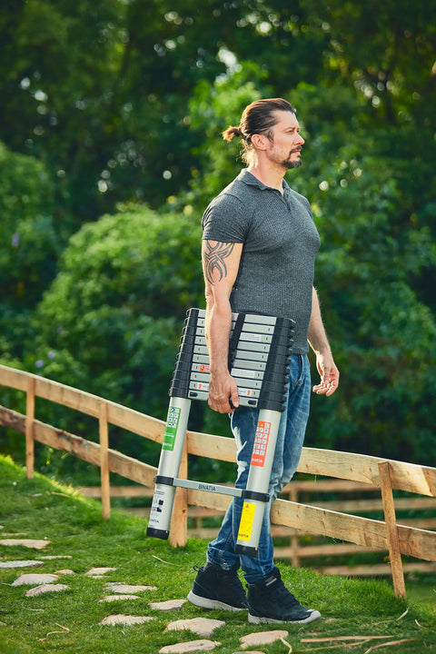 Man carrying 8.5 Ft Aluminum Telescoping Ladder For Home DIY Projects Foldable Extension With 12 Ft Reach Lightweight Portable