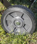 Close-up of the wheel on a 40 Inch Tow Behind Lawn Dethatcher Beast With 20 Durable Spring Steel Tines, Universal Hitch, on grass