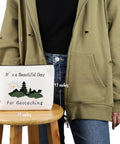 Person holding Geocaching Makeup Bag For Outdoor Lovers It Is A Beautiful Day For Geocaching Gift Beige Durable Canvas Zip Bag