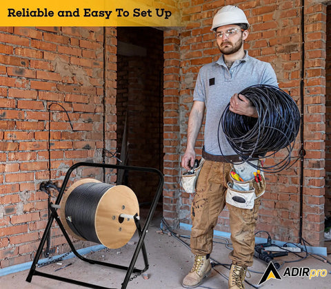 Construction worker with Single Axle Cable Reel Caddy built to last heavy duty industrial steel wire dispenser on site.