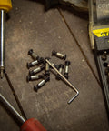 10 Pack Handle Screws, Rivets, Bolts, And Fasteners With Hex Key For DIY Knife Making And Fixed Blade Repairs on wooden surface
