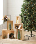 Vintage Rustic Wood Crates Set Of Five Nesting Storage Boxes With Open Handles displayed beside a decorated Christmas tree