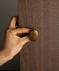 Close-up of hand installing antique brass zinc alloy drawer knob, Six Pack Zinc Alloy Drawer Knobs In Big Oval Antique Brass Finish