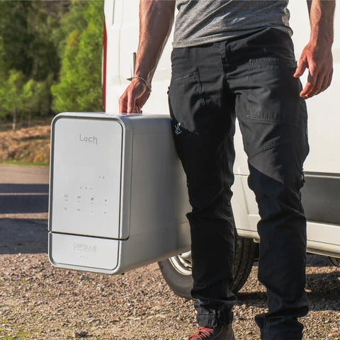 No Drama Portable Countertop Dishwasher With Dead Simple Fifteen Minute Wash Cycle Auto Dry Function Plumbing Free Setup Real Deal For Tiny Kitchens Dorm Rooms And Rv Road Trips held beside a van.