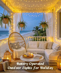 Two Pack Outdoor String Lights Battery Operated, 66 Ft Total, 200 LED Fairy Lights adorn a cozy beachside porch setting