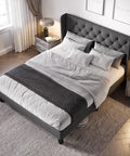 Modern Queen Bed Frame with Sturdy Button Tufted Wingback Headboard in Cool Dark Grey Upholstered Platform Setup with bedding.