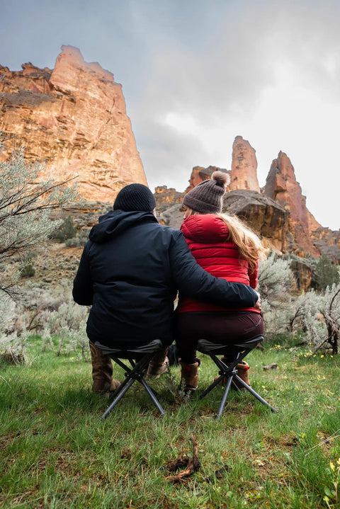 Couple sitting outdoors on Apex Fold-Up Stool G-140 Black Grey Ultra Portable Camp Seat for camping, hiking, sturdy support