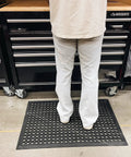 Person standing on Anti Fatigue Rubber Floor Mat With Drainage Holes For High Traffic Areas Grippy Non Slip Doormat in garage