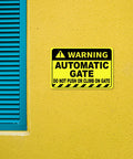 Heavy Duty No Sweat Automatic Gate Warning Sign 8X12 Inches Rust Proof Aluminum mounted on yellow wall.