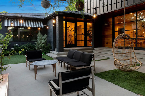 Ambience Pro Solar Powered Outdoor String Lights With Remote Control And Edison Bulbs hanging over a modern patio setup