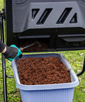 Person extracting compost from 42 Gallon Black Outdoor Garden Compost Tumbler Bin With Dual Chambers Rotating For Continuous Composting