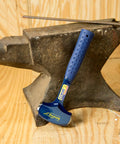 Heavy Duty 4 Pound Drilling And Crack Hammer, USA Made Sledge Hammer with blue grip against an anvil on wooden floor
