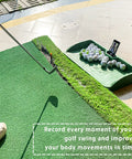 Heavy Duty Golf Ball Tray With Cell Phone Holder For Recording Your Swing, 100 Ball Capacity, High Impact Rubber Construction, Compatible With All Hitting Mats, placed on a driving range with balls and phone