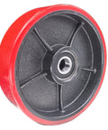 Close-up view of a red 7x2 inch pallet jack steering wheel with preinstalled bearings and axle for industrial use.