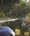 Person using a hose with Two Piece Brass Garden Hose Quick Connect Fittings Set For Hoses Nozzles And Sprinklers With Push Pull Ring in a garden.