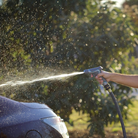 Person using a hose with Two Piece Brass Garden Hose Quick Connect Fittings Set For Hoses Nozzles And Sprinklers With Push Pull Ring in a garden.