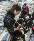 Divers on boat preparing gear, highlighting Beefy Titanium Dive Knife With 3.5-Inch Blade, Locking Sheath, And BCD Mount Kit For Scuba Gear.