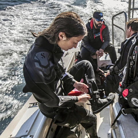 Divers on boat preparing gear, highlighting Beefy Titanium Dive Knife With 3.5-Inch Blade, Locking Sheath, And BCD Mount Kit For Scuba Gear.