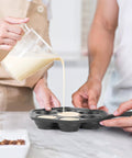 Pouring batter into Seven Section Cast Iron Danish Aebleskiver Pan For Mini Puffs And Pancake Balls Preseasoned Heats Evenly