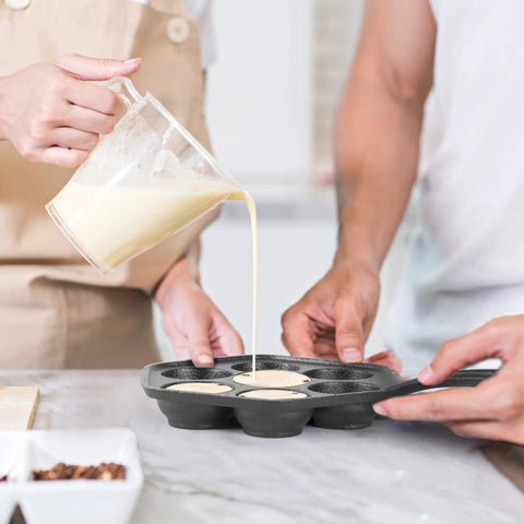 Pouring batter into Seven Section Cast Iron Danish Aebleskiver Pan For Mini Puffs And Pancake Balls Preseasoned Heats Evenly