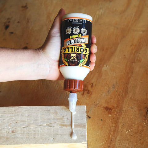 Hand squeezing Ultimate Waterproof Wood Glue For Indoor And Outdoor Projects In Natural Wood Color, 8 Oz Pack Of 2 onto wood