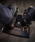 Close-up of feet on Precision Flight Sim Rudder Pedals for PS5, Xbox, and PC With Long Travel Axis on wooden floor.