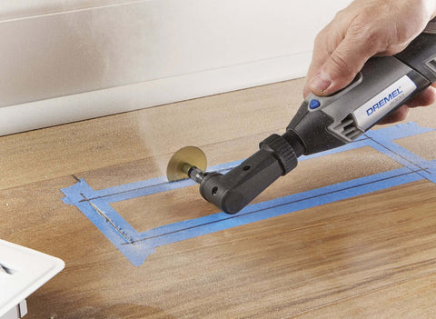Dremel 575 right-angle attachment on a rotary tool grinding a wooden surface.
