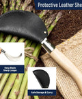 8 Inch Hand Sickle Hawkbill Garden Knife with Beechwood Handle for harvesting, shown with leather sheath on asparagus pile.