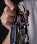 Person holding Heavy Duty Titanium Key Ring Set With Side Push Design For Easy One Hand Access Split Keyring And Carabiner Keychains