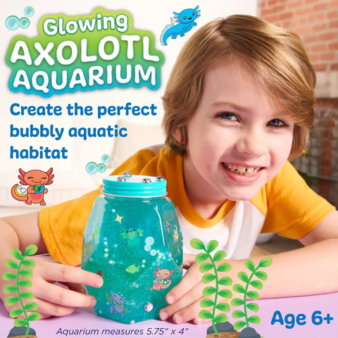 Totally Glowing Axolotl Aquarium Craft Kit For Kids Ages 6 And Up With Five Mini Axolotls, Glow In The Dark Decor, And STEM Fun, Hands On Arts And Science Gift For Girls And Boys. Child holding plastic axolotl aquarium, 5.75 x 4 in