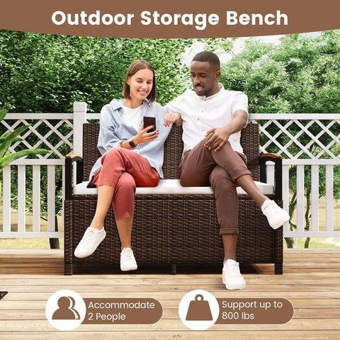 Two people seated on Wicker Outdoor Storage Bench With Hidden 46 Gallon Gas Strut Lift Up Storage, rattan design.
