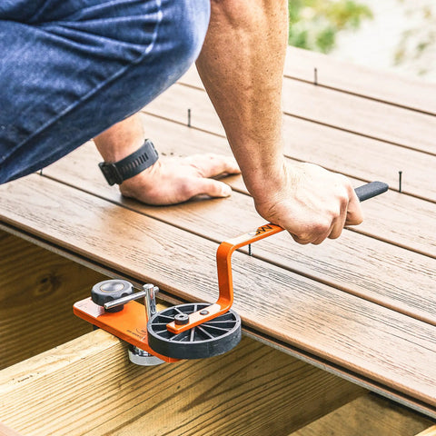 Image of Heavy Duty Deck Board Straightener And Bow Clip Lever Tool being used to align warped lumber on a deck.