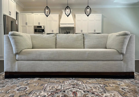 Adjustable Under Couch Gap Shield Blocking Toys Dust And Remotes From Snaking Under Sofas with flexible core, shown in modern living room.