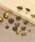 Total Breeze 100 Pcs Top Shelf Upholstery Tacks With 3/8 Inch Round Head And 0.35 Inch Length smooth metal push pins on wood.