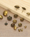 Straight Up Premium 200 Pack Heavy Duty Upholstery Tacks With Round Metal Thumb Nail Pins Vintage Hardware arranged on wood.