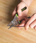 Person using stainless steel wire stripper for 10-18 AWG solid and 12-20 AWG stranded on a wooden table