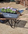 Five Cubic Foot Heavy Duty Garden Cart With 15 Inch Flat Free Tire for gardening, showing steel frame and planted flowers.