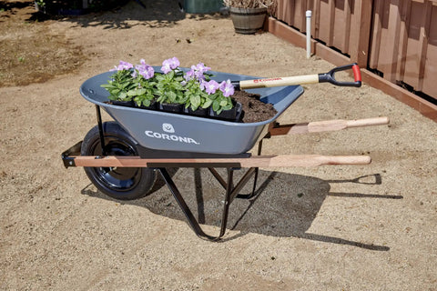 Five Cubic Foot Heavy Duty Garden Cart With 15 Inch Flat Free Tire for gardening, showing steel frame and planted flowers.