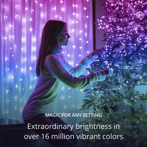 Person decorating tree with 65.6 Feet Indoor Outdoor Smart RGB LED String Lights With Over 16 Million Dope Colors, creating vibrant ambiance.