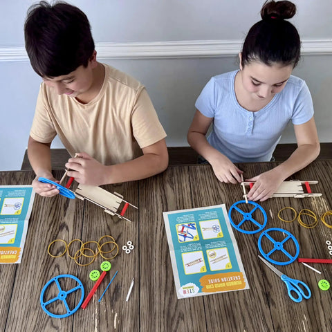 Kids assembling DIY Rubber Band Powered Car Kit For Kids 2-Pack Hands-On STEM Project with wooden parts and instructions on table